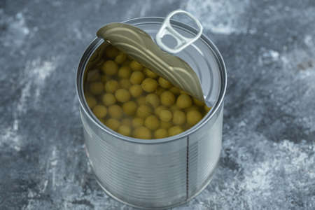 Close up photo of opened tin green olives on grey backgroundの写真素材