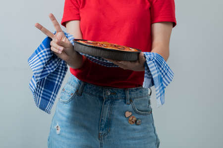 A model holding a sweet pie in a black panの写真素材
