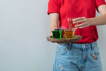 A model holding a platter of colorful drinksの写真素材