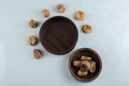 Bowl of dried figs around wooden plate