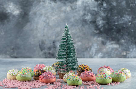 Cookies decorated with sprinkles around pine treeの写真素材