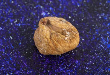 Single dried fig on blue backgroundの写真素材