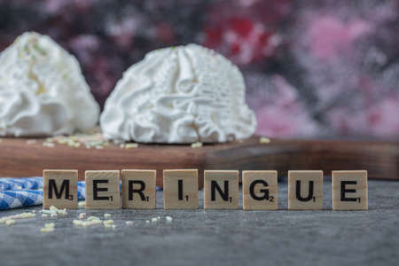 Meringue writing with wooden dices around the cookie boardの写真素材