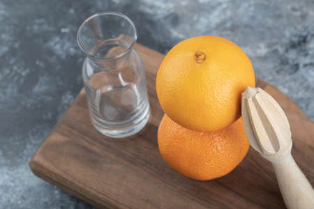 Empty glasses and orange on wooden board