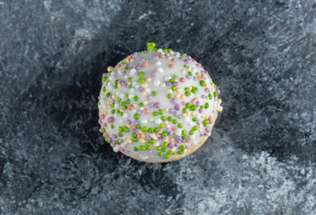 Round cookie with white chocolate frosting on marble background