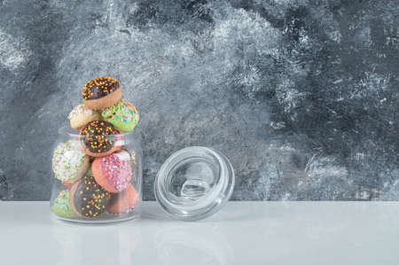 Colorful cookies with sprinkles in glass jarの写真素材
