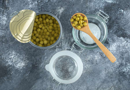 Opened olive tin with jar over grey backgroundの写真素材