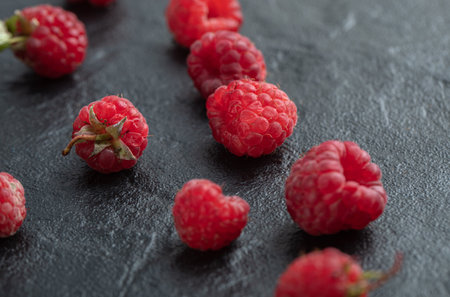 Pile of red raspberries on black backgroundの写真素材