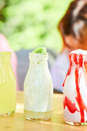 A milkshake and two lemonades on wooden table, close upの写真素材