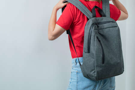 Schoolgirl wearing her grey backpack to shouldersの写真素材