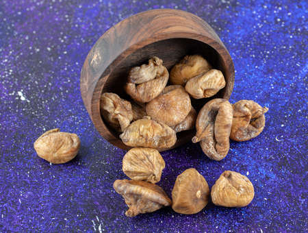 Bowl of dried figs on blue backgroundの写真素材