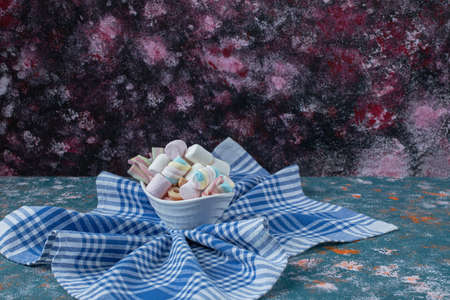 Colorful marshmallows and jellybeans in a white platterの写真素材