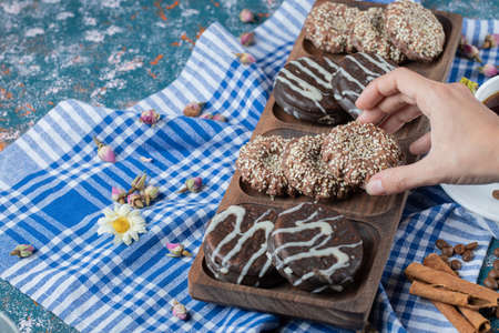 Chocolate and sesame cookies on a wooden board