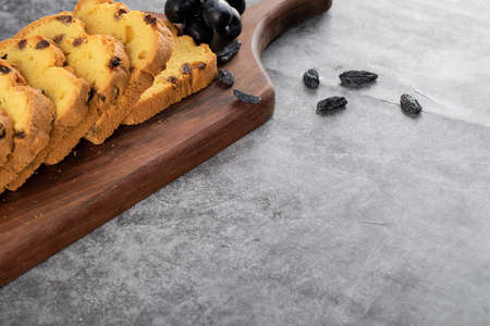 Fresh roulette slices with grape on wooden chopping boardの写真素材