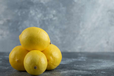 Stack of ripe lemons over grey background
