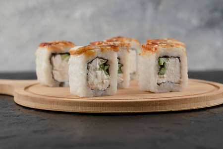 Tasty dragon sushi rolls with eel on wooden board
