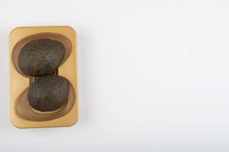 Two fresh healthy brown avocado isolated on white-gray backgroundの写真素材