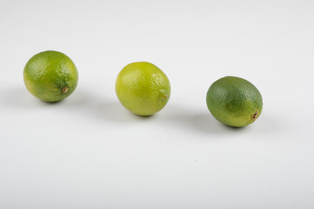 Three ripe lime fruits isolated on white backgroundの写真素材
