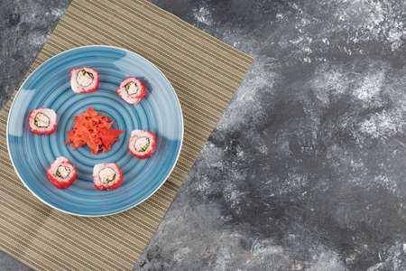 California sushi rolls and pickled ginger on blue plate