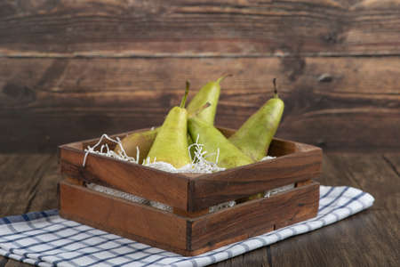 Wooden box of delicious ripe pears on wooden backgroundの写真素材