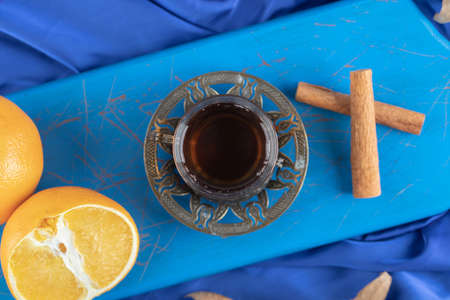 Top view of glass of tea with cinnamon stick and fresh lemon