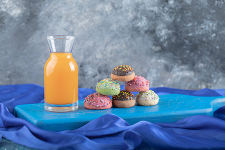 Fresh juice and homemade cookies on blue wooden boardの写真素材
