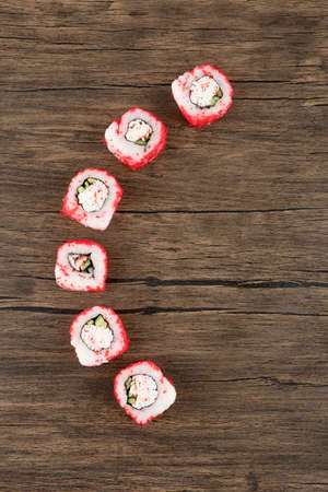 Delicious california sushi rolls placed on wooden surfaceの写真素材