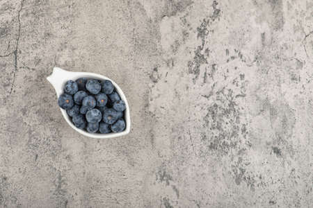 Small bowl of delicious fresh blueberries on marble surfaceの写真素材