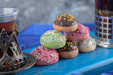 Close up photo of Glass of tea with jar of cookie on blue boardの写真素材