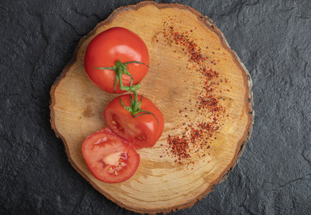 Fresh ripe tomatoes with red hot chili pepper on wooden boardの写真素材