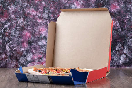 Hot Mixed Pizza in open box over wooden tableの写真素材