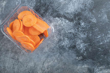 Top view of plastic container full with carrot slicesの写真素材