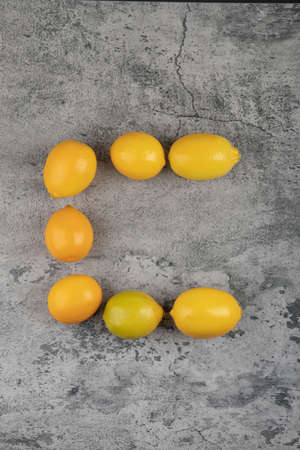 Bunch of fresh yellow lemons placed on stone surface