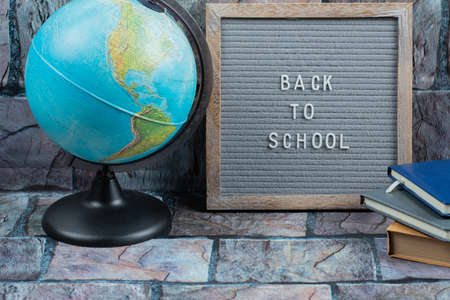 Back to school phrase embedded on grey tissue with a globe around