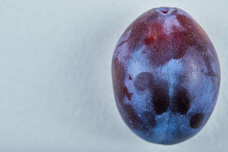 Fresh ripe plum on a blue backgroundの写真素材