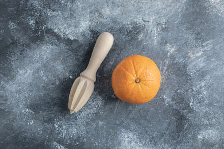 Oranges and wooden reamer on marble backgroundの写真素材
