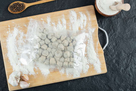 Raw dumplings with flour on a wooden boardの写真素材