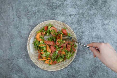 A wooden plate of delicious vegetable saladの写真素材