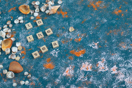 Wooden dice with printed letters on them on blue backgroundの写真素材