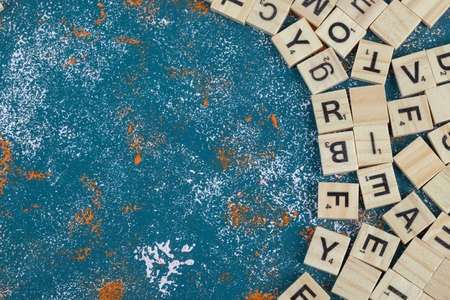 Wooden dice with printed letters on them on blue backgroundの写真素材