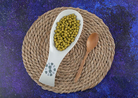 Wooden spoon and ceramic bowl full with marinated oliveの写真素材