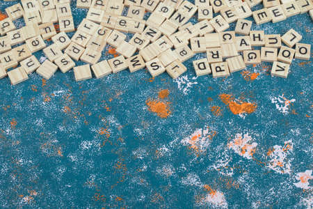 Wooden dice with printed letters on them on blue backgroundの写真素材