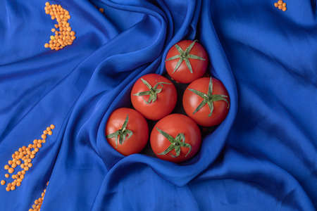 Fresh red tomatoes on blue tableclothの写真素材