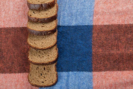 A line of slices of brown bread on a tablecloth