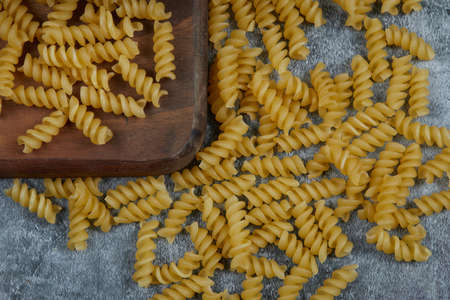 Scattered raw pasta on blue backgroundの写真素材