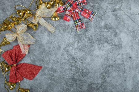 Christmas golden bells and ribbons on marble background