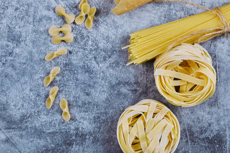 A bunch of various raw pasta on blue backgrounds