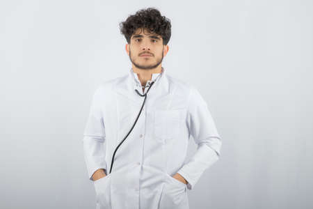 Mid-adult Caucasian male doctor with eye chart in background.