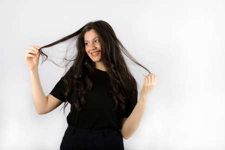 Young beautiful lady stretching her hair and looking awayの写真素材