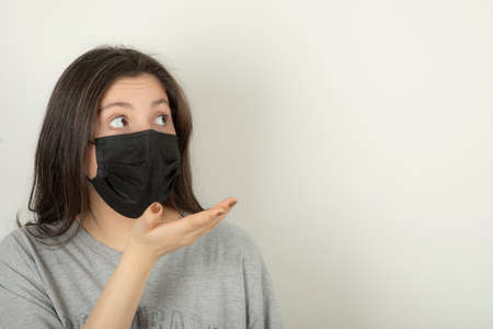 Young woman wearing mask and looking awayの写真素材